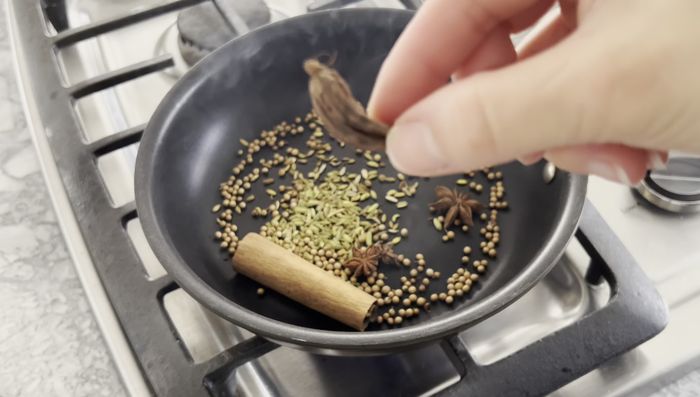 Toast spices (cinnamon stick, coriander seeds, fennel seeds, black cardamom pod, star anise) in a dry pan over medium heat until fragrant. Place in a tea bag (optional).