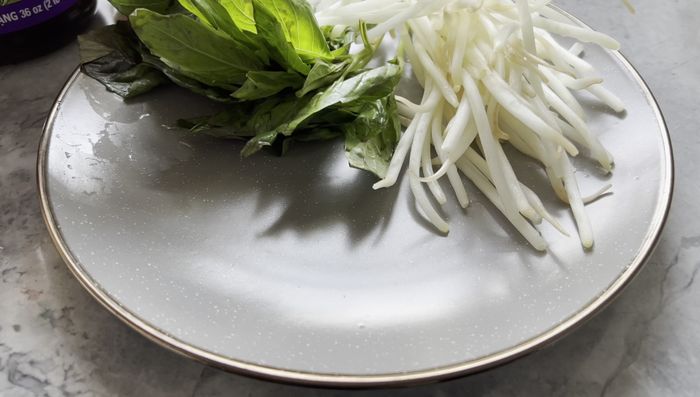 Serve oxtail pho with noodles and desired toppings.