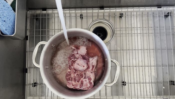 Parboil oxtail and beef bones in separate large pots until water boils. Discard the gunk, rinse the meat until clean, and set aside.