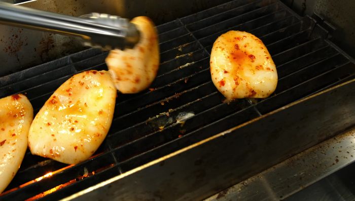 Grill the squid, flipping once it shrinks slightly. Don't overcook to avoid toughness.