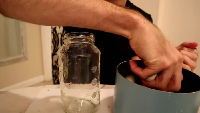Place the eggplants, chili pepper, and half of the onion (to weigh down the eggplants) into a jar.