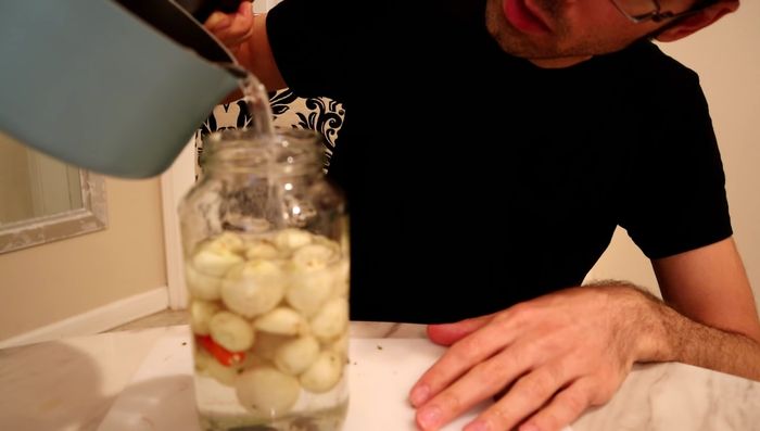 Pour the brine over the eggplants in the jar.