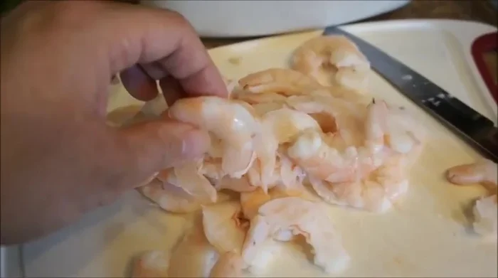 Peel and cut the cooked shrimp in half.