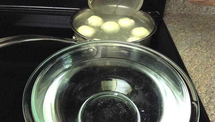 Transfer the cooked dumplings to a bowl of cold water to cool. Drain and place them on a greased banana leaf or dish.
