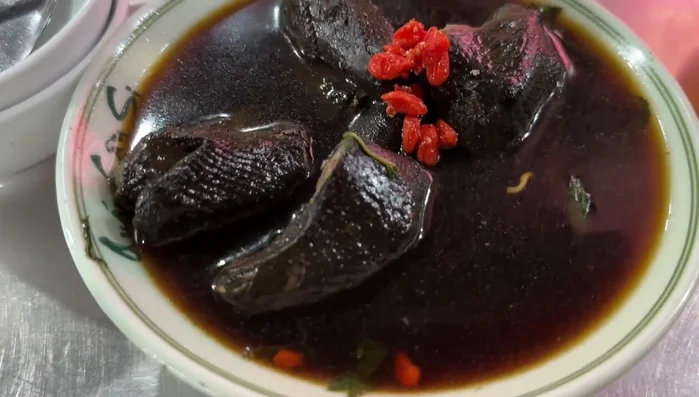 Cook the chicken in a pot until tender. The broth is likely simmered for a considerable time.