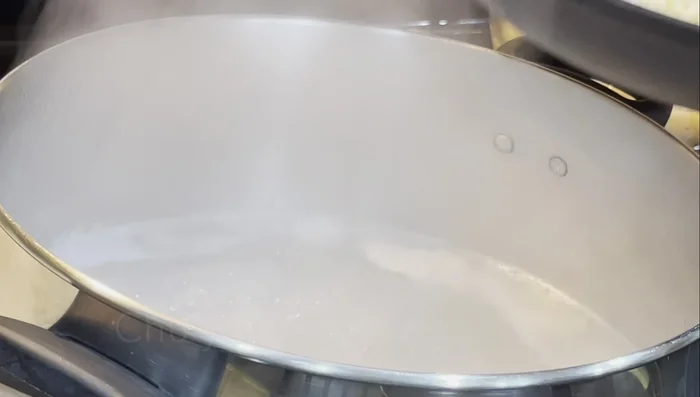 Carefully add the blanched clams and rice into the pot, stirring frequently to avoid overflow.