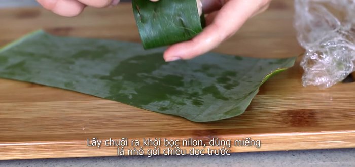 Remove the plastic wrap and wrap the sticky rice-banana bundle in banana leaves. (193.71)