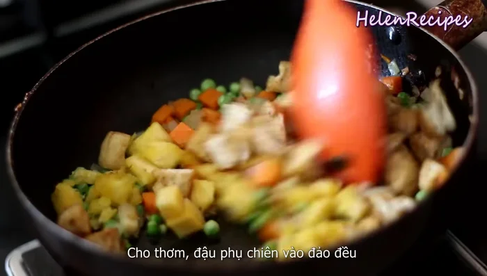 Combine ingredients: Add the pineapple and fried tofu cubes. Stir well, lower the heat, and season with salt, vegetarian chicken stock, and soy sauce.