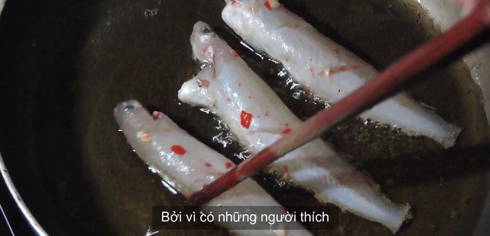 Heat oil in a frying pan, add garlic, and fry the marinated goby fish until golden and crispy.