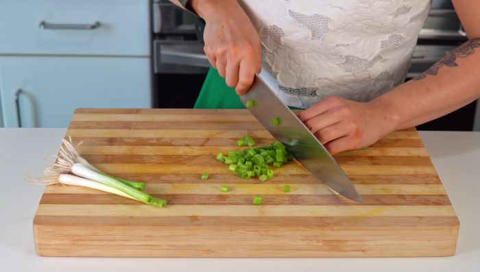 Chop green onions (separate white and green parts). Chop other herbs (cilantro, culantro, etc.) for serving.