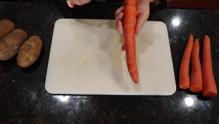 Prepare the carrots and potatoes by peeling and cutting them into bite-sized pieces.