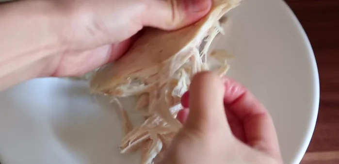 Remove cooked chicken, let it cool, then shred it.