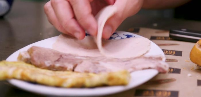 Assemble the Banh Mi (Northern Style): Hollow out a portion of the baguette if desired. Layer the fillings in a moderate amount including the pate, ham, head cheese and a sprinkle of Maggi seasoning. (47.19)