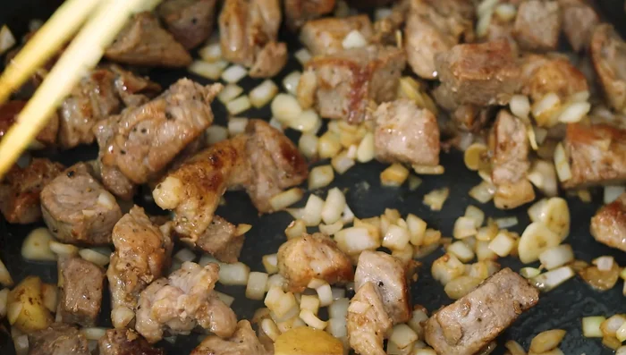 Add onion, garlic, and ginger to the pork. Cook until onions are translucent and garlic/ginger are fragrant.
