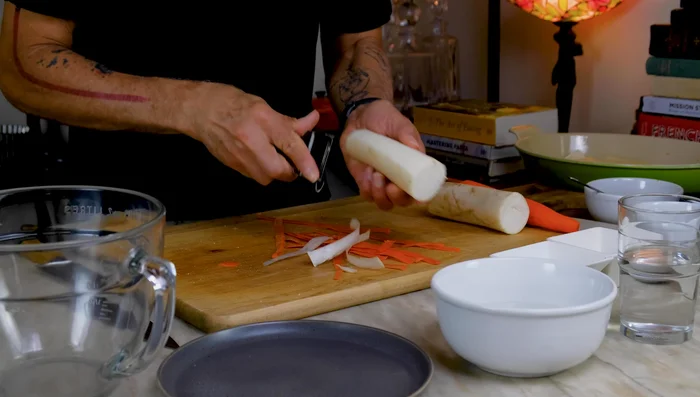Prepare the pickled daikon and carrots: Peel and slice them into 1/4-inch thick pieces, then julienne into matchsticks. Massage with sugar and salt for 20 minutes until softened.