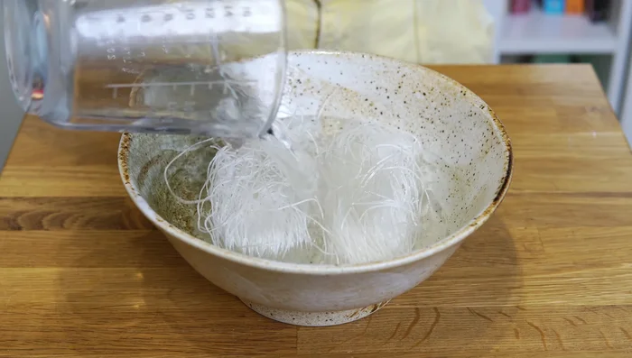 Add the noodles to a large bowl, cover with room temperature water, and set aside to soak.