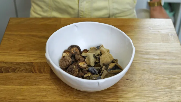 Add shitake and wood ear mushrooms to a heatproof bowl, pour in boiling water, cover, and set aside to rehydrate.