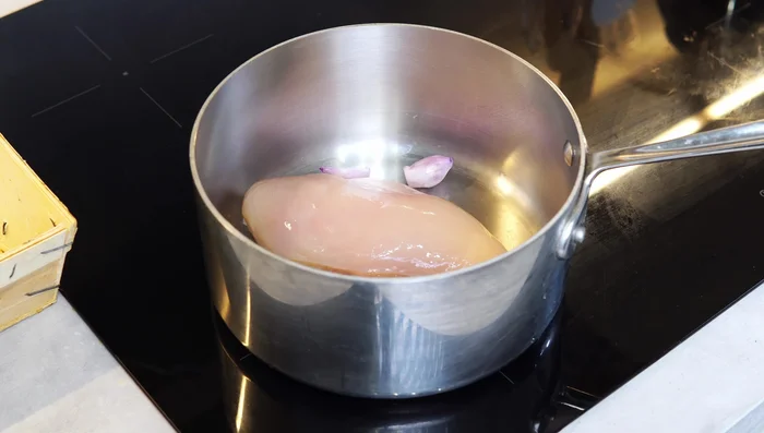 Cut shallots, add to a pot with chicken breast, sliced ginger, salt, and enough water to cover the chicken completely. Heat on medium-high until boiling, skim impurities, reduce heat to medium-low, cover, and simmer for 15-20 minutes or until chicken is cooked through.