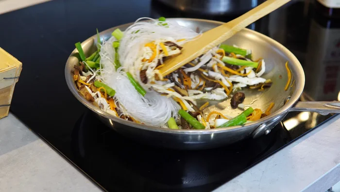Add noodles, green onion, and some chicken cooking liquid; sauté for about a minute. Add soy sauce, cook, adding more liquid as needed, and stir until noodles are softened (1-2 minutes).