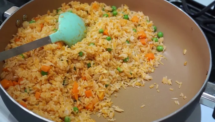 Push the rice to one side of the pan, and cook the eggs in the empty space.