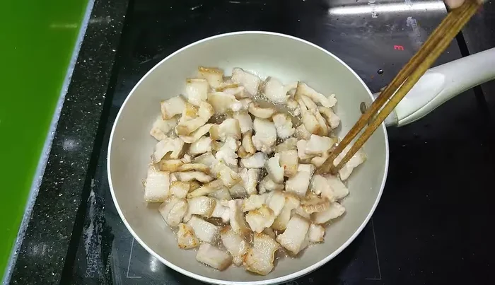 Place the sliced lard on a non-stick pan, cover, and let it steam for a while to render the fat faster and more evenly. Alternatively, boil the meat first before rendering the fat.