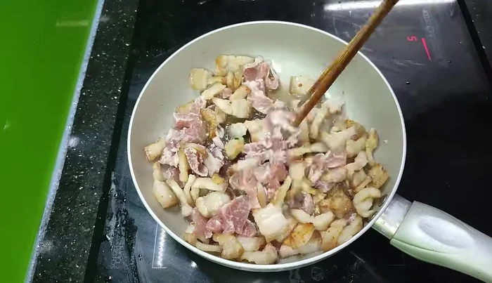 After about 50-60 minutes of rendering the fat, add shallots and a little more meat to the pan.