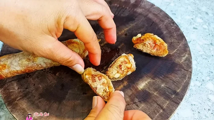 Serve the sausages in bread with chili sauce, Vietnamese coriander, and pickled onions/cucumber.