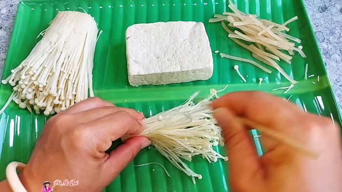Separate enoki mushrooms into small pieces. Use a toothpick to pull them lengthwise to separate the fibers. Squeeze dry.
