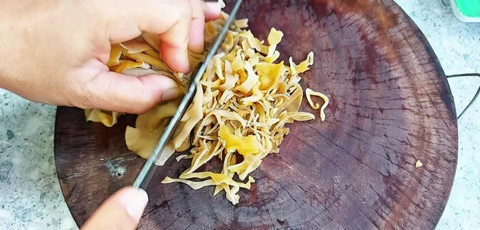 Soak wood ear mushrooms until soft, clean, remove roots, and chop.