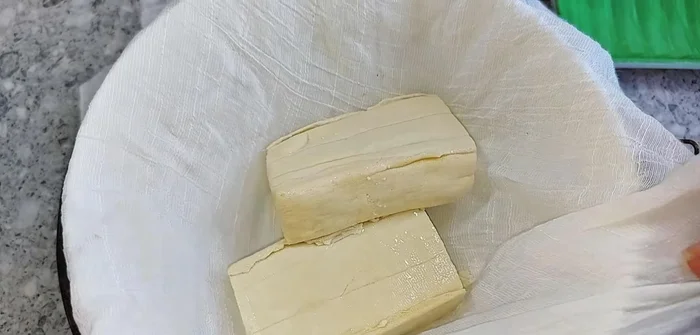 Prepare the tofu by squeezing out excess water using a cloth bag.