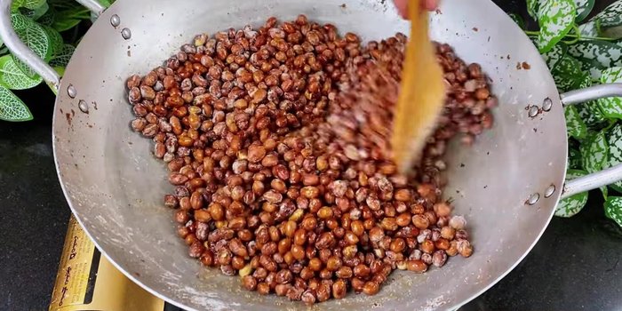 Add the prepared sauce (sugar, fish sauce, chili sauce) to the peanuts; stir well over medium heat for about 1 minute until the peanuts absorb the spices.