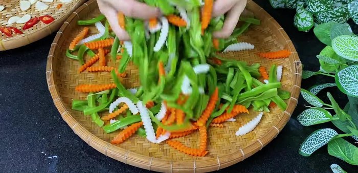 Combine the prepared carrots, white radish, Rau Tien Vua, chili, and garlic. Mix well.