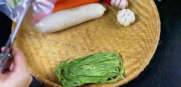 Prepare the Rau Tien Vua: Cut the vegetable and soak it in a warm water mixture (2 parts cold water, 1 part hot water) to soften and maintain crispness. This will help it expand.