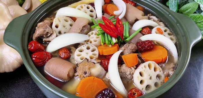 Serve the hot pot with fresh noodles and garnish with green onions.