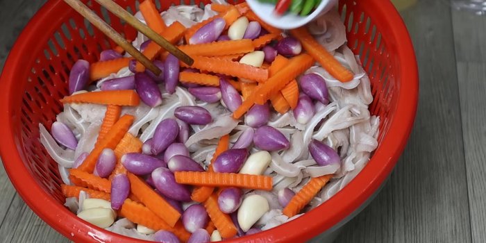 Combine the prepared pig's ears, marinated carrots, onions, garlic, and chili peppers in a clean jar.