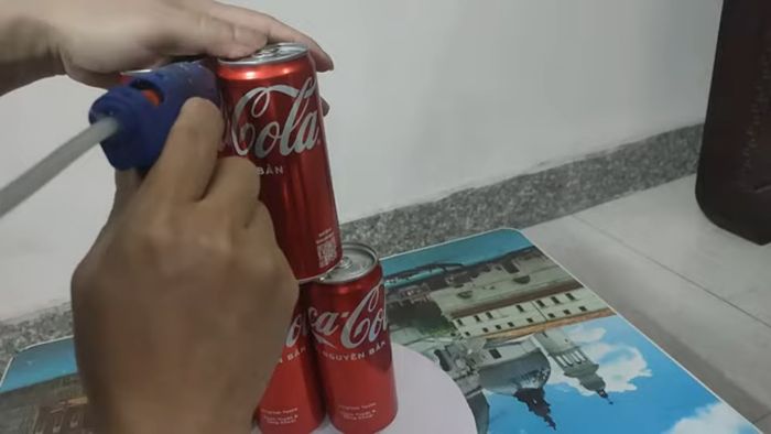 Attach three cans of water to the bottom level, two to the top, and two to each side.