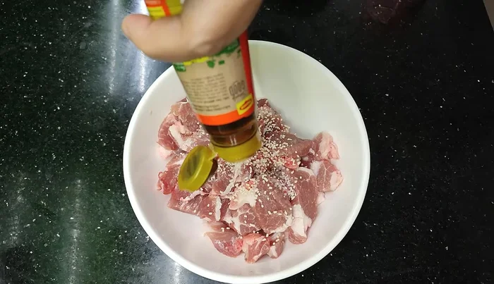 Marinate the crispy shoulder meat with sesame seeds, MSG, and Hao oil. You can add shallots, fish sauce, and/or ground galangal juice for extra flavor.