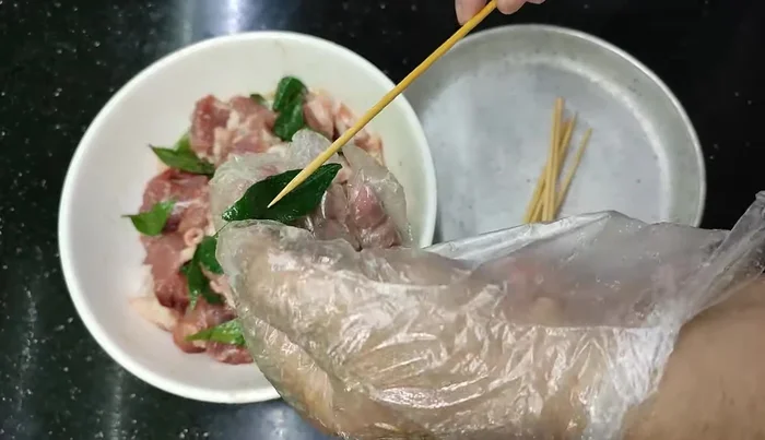 Thread the marinated meat and honey leaves onto skewers.