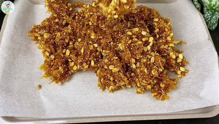 Pour the candy onto a parchment-lined tray. Roll it out evenly to desired thickness. Sprinkle with remaining sesame seeds.
