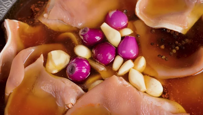 Add pig ears, shallots, garlic, peppercorns, and cooking wine to the pot. Simmer covered over medium heat for 40 minutes, turning pig ears every 5 minutes for even cooking.