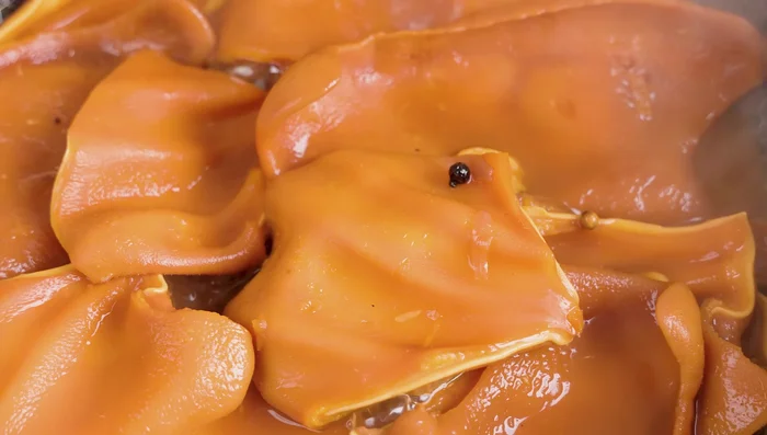 Once soft, remove pig ears from the pot. Cut some into smaller pieces.