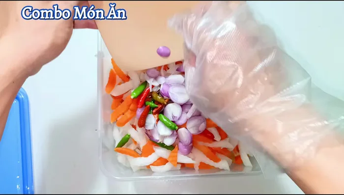Once the pickling liquid is cool, add the drained radish and carrots, along with sliced purple onion and chili (optional). Mix well.