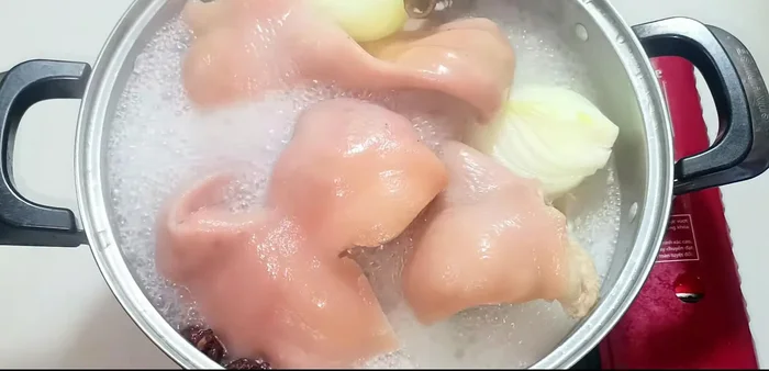 Once boiling, reduce heat to medium and simmer for 20 minutes. Flip the pig hands and continue simmering for another 20 minutes, until cooked through and fragrant.