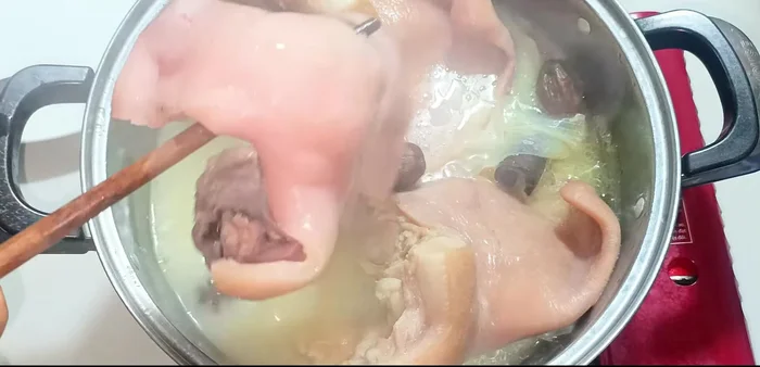 Remove the pig hands and snout from the pot. Scoop out the remaining ingredients from the cooking liquid.
