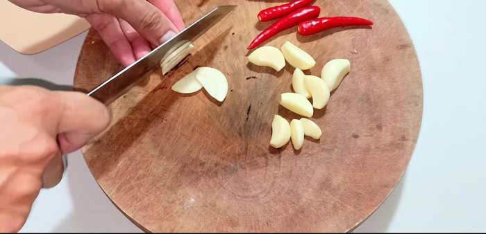 While the pickling liquid cools, prepare the garlic and chili. Slice the garlic and chop the chili peppers (adjust the amount depending on your spice preference).