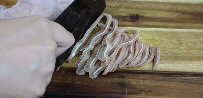 Remove pig ears from cold water and slice. (157.959)