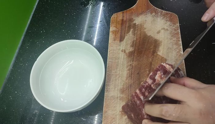 Slice the beef against and along the grain to a thickness of about 0.5 cm.