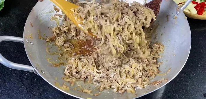 Assemble the spring rolls: Layer the filling onto the leaves, add garlic and chili, compress tightly, and roll up. Secure with elastic bands. (445.08)