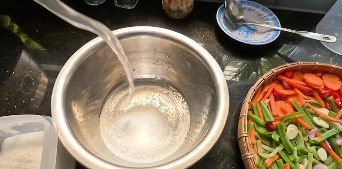 Prepare pickled vegetables: Mix sugar and rice vinegar. Add sliced vegetables, stir, and soak for 1 hour.