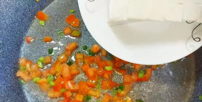 Cook tofu in tomato sauce: Saute onions. Add tomatoes and tofu. Season with sugar, vegetarian seasoning, chili sauce, and vegetarian fish sauce. Cook until tomatoes melt and sauce thickens.